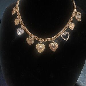 Gold-tone necklace featuring multiple dangling heart charms.